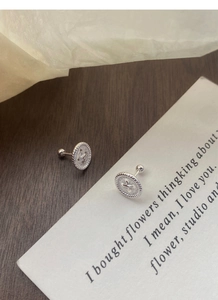 Macro detail of S999 sterling silver button studs with twisted texture and screw backings