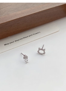 Detail of S999 silver cat and fishbone stud earrings with sparkling zircon inlay