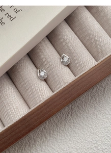 Detailed close-up of S999 silver water-drop zircon earrings on beige fabric
