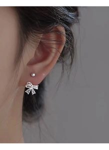 Vue macro d'une boucle d'oreille nœud creux en argent S999 et clou d'oreille rond