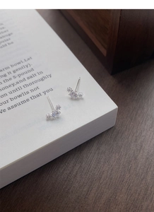 Macro shot of S999 sterling silver stud earrings with zircon on an open book page