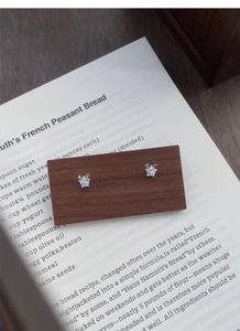 Vue détaillée des boucles d'oreilles étoile en argent avec zircons sur socle en bois