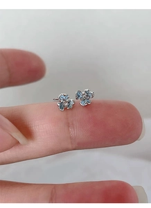 Gros plan d'un clou d'oreille iris en argent avec émail bleu et petit diamant brillant