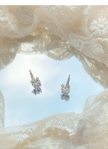 Gros plan de boucles d'oreilles étoile en argent S999 et zircon sur fond de dentelle