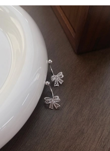 Vue macro de boucles d'oreilles nœud en argent avec texture mesh et détails cœur