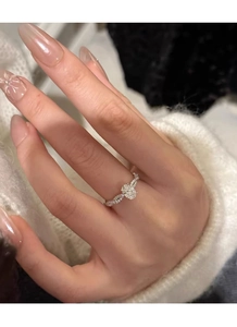 Detail of S925 silver ring featuring an oval gemstone and twisted pavé diamond band
