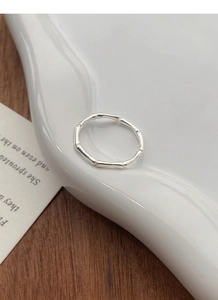 Close-up of S999 sterling silver bamboo joint ring on a white ceramic display tray