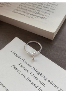 Detailed close-up of S925 sterling silver bow ring with dangling bead and zircon accents