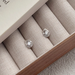 Elegant S999 silver snake stud earrings with zircon stones in a beige jewelry box