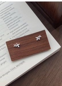 Detail of S999 sterling silver osmanthus earrings with sparkling zircons on wood