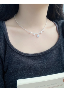 Détail d'un collier en argent S925 avec disque micro-pave et breloques en zircone