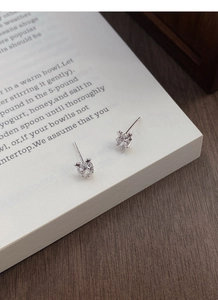 Vue macro de boucles d'oreilles étoile en argent S999 avec pierres sur pages de livre