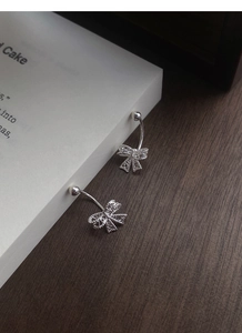 Détail macro de boucles d'oreilles nœud creux en argent S999 avec fermoir à vis
