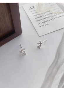 Close-up of S999 sterling silver sweet osmanthus flower earrings on a minimalist background