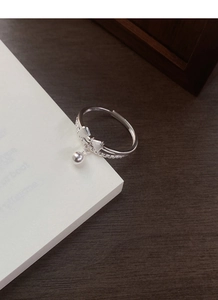 Detail of S925 silver bow ring with matte finish, bell pendant, and hallmark engraving