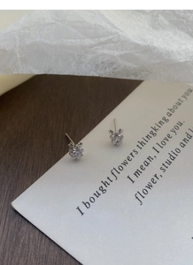 Vue détaillée des boucles d'oreilles étoiles en argent fin S999 avec oxydes de zirconium