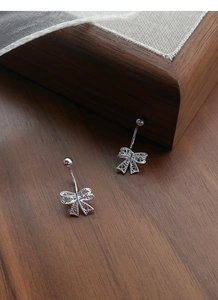 Vue détaillée de la boucle d'oreille nœud en argent S999 avec gravure creuse fine