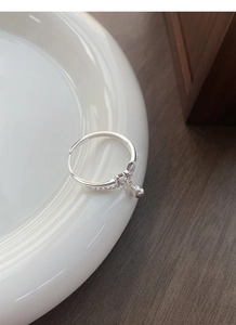 Detailed close-up of a S925 sterling silver adjustable ring with bead and bell charm