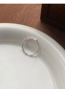 Detailed macro view of the S999 sterling silver bamboo joint ring on a white ceramic tray