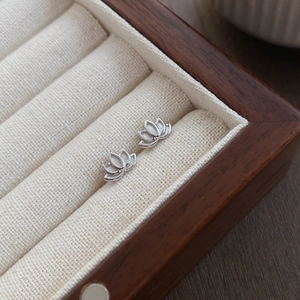 Minimalist S999 sterling silver lotus stud earrings displayed in a wooden jewelry box