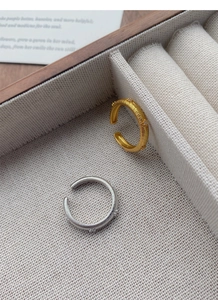 Detail view of retro S925 silver star rings with brushed texture in a velvet jewelry box