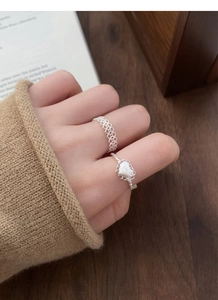 Gros plan sur bague en argent S925 à motif dentelle et bague coeur givré au doigt