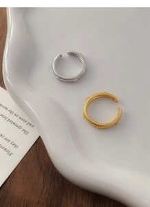 Detailed view of gold and silver S925 sterling silver rings with brushed spiral texture