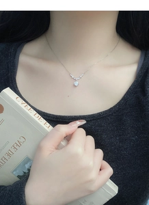 Gros plan détaillé d'un collier fleur en argent avec zircon goutte sur un mannequin