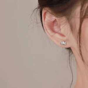 Elegant S999 silver lotus stud earrings with sparkling white zircons on ear lobe