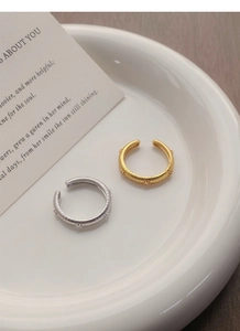 Close-up of S925 sterling silver star rings with brushed texture in gold and silver