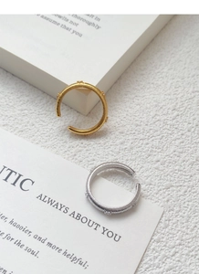 Detailed view of gold and silver S925 sterling silver rings with brushed stripe texture