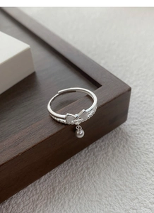 Macro view of S925 sterling silver double layer ring with bow knot and round bead charm