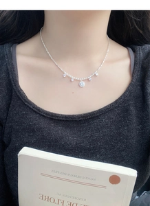 Gros plan d'un collier ras du cou en perles avec pendentifs en zircon sur un mannequin femme