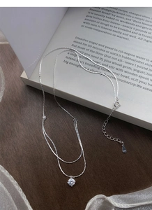 Macro shot of S925 sterling silver stamp and double-layered necklace with sparkling stone