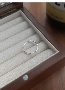 Macro detail of silver bamboo joint ring inside a wooden jewelry gift box