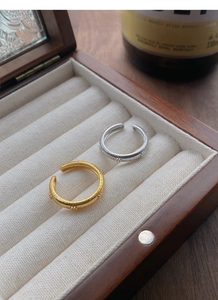 Close-up of gold and silver S925 rings with star studs on a velvet jewelry box