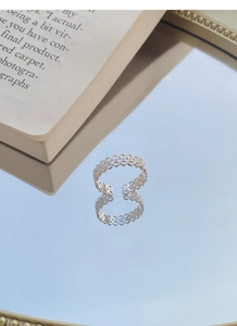 Macro d'une bague en argent S925 dentelle avec détails de cœur et texture brossée
