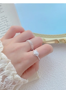 Détail d'une bague en argent S925 avec cœur et anneau en dentelle au style élégant