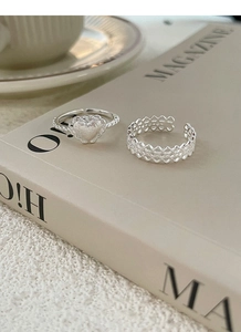 Détail de la bague en dentelle argent S925 et bague cœur mat sur un magazine