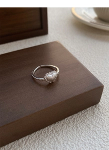 Détail macro d'une bague en argent S925 avec cœur mat et bordure en dentelle délicate