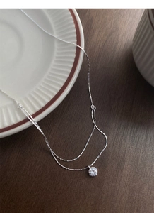 Detailed view of double-layer S925 silver necklace with sparkling solitaire cubic zirconia
