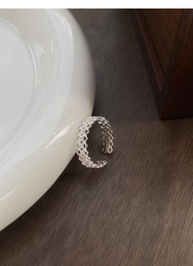 Détail d'une bague en argent S925 avec motif dentelle et anneau ouvert ajustable