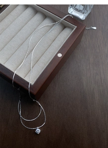 Detail of S925 sterling silver solitaire necklace on a premium wooden jewelry box