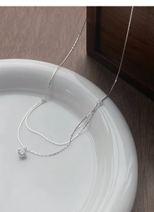 Detail of S925 sterling silver double layer necklace with a round cubic zirconia pendant