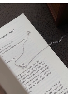 Close-up of S999 sterling silver airplane bracelet with sparkling crystals on book pages