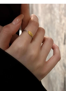 Macro view of minimalist silver and gold ring with letter engraved on the leaf