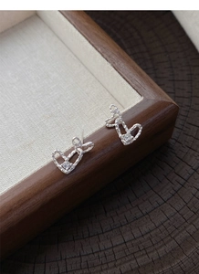 Macro view of interlocking heart earrings with hammered texture and a single zircon stone