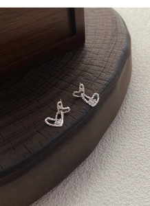 Macro shot of S999 sterling silver double heart earrings with textured finish and zircon