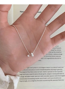 Macro detail of S925 silver necklace with sparkling zircon pendant on a book