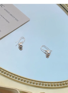 Macro di orecchini a goccia in argento sterling S925 lucido su superficie a specchio